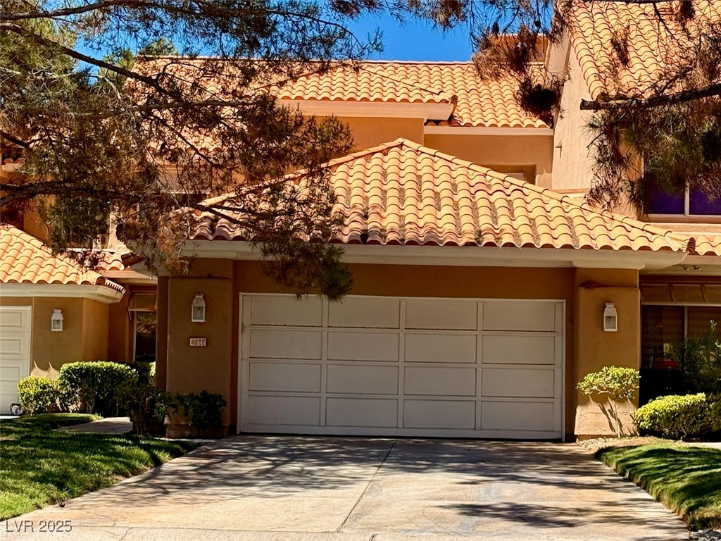 4969 Jeremy Drive Las Vegas, NV 89113 - Photo 2 of 73 Mediterranean / spanish house with a tiled roof, an attached garage, stucco siding, and concrete driveway