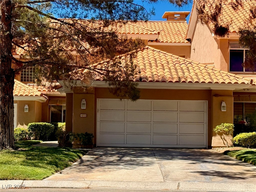 4969 Jeremy Drive Las Vegas, NV 89113 - Photo 4 of 73 Mediterranean / spanish-style house with stucco siding, a tiled roof, and concrete driveway
