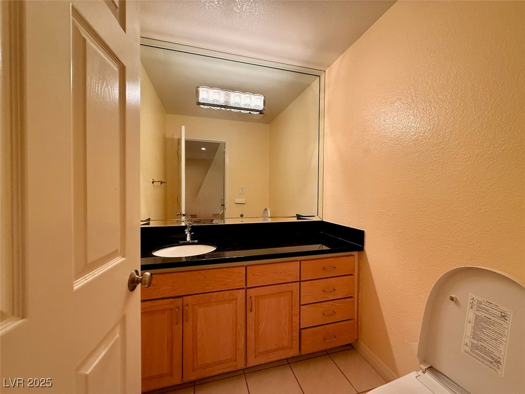 4969 Jeremy Drive Las Vegas, NV 89113 - Photo 41 of 73 Half bathroom featuring vanity, light tile patterned flooring, and a textured wall