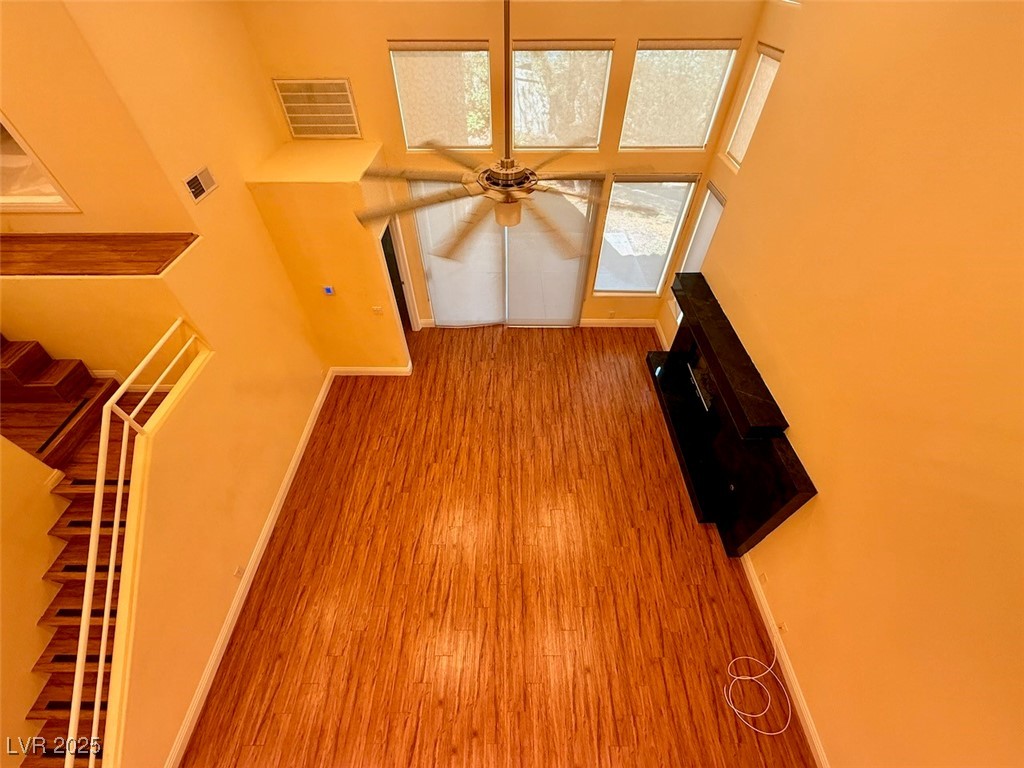 4969 Jeremy Drive Las Vegas, NV 89113 - Photo 47 of 73 Unfurnished living room featuring light wood-style flooring, a towering ceiling, and ceiling fan