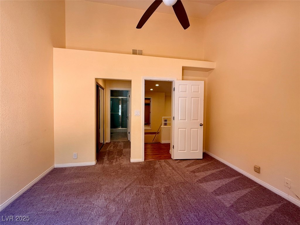 4969 Jeremy Drive Las Vegas, NV 89113 - Photo 50 of 73 Unfurnished bedroom with connected bathroom, dark colored carpet, ceiling fan, and a towering ceiling