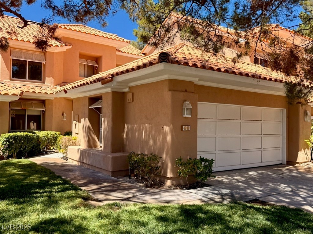 4969 Jeremy Drive Las Vegas, NV 89113 - Photo 5 of 73 Mediterranean / spanish house featuring stucco siding, driveway, a tiled roof, and a front lawn