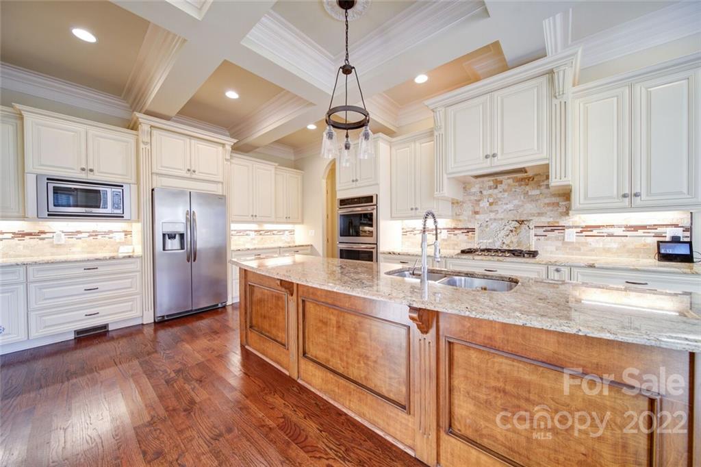 174 Birdie Drive Stanley, NC 28164 - Photo 5 of 46 a kitchen with stainless steel appliances granite countertop a refrigerator a stove and white cabinets with wooden floor
