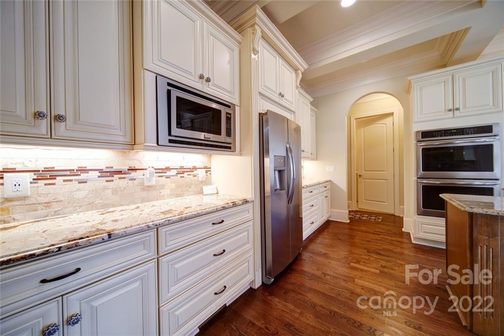 174 Birdie Drive Stanley, NC 28164 - Photo 6 of 46 a kitchen with granite countertop cabinets stainless steel appliances and wooden floor