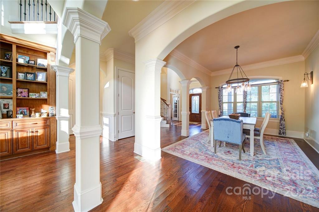 174 Birdie Drive Stanley, NC 28164 - Photo 8 of 46 a dining room with wooden floor a chandelier a wooden table and chairs