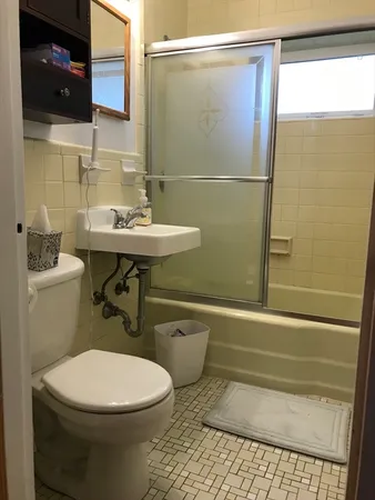 a bathroom with a sink a toilet and shower