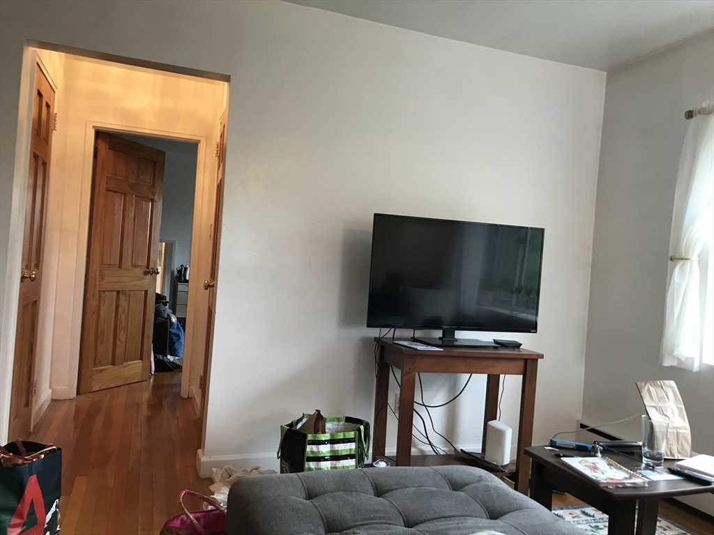 76 Euston Road, Unit 10 Boston, MA 02135 - Photo 2 of 11 a living room with furniture and a flat screen tv