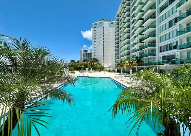a view of swimming pool with chairs and a yard
