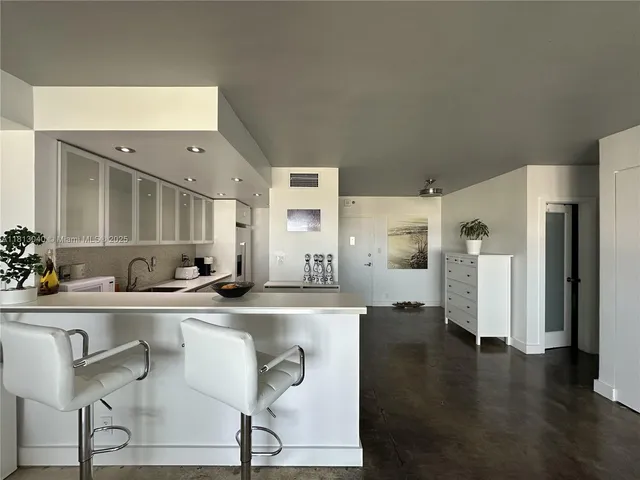 a kitchen with stainless steel appliances granite countertop a sink and a refrigerator
