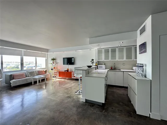 a living room with furniture and kitchen view