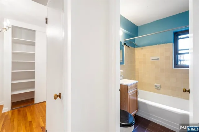 a bathroom with a bathtub a shower and a vanity