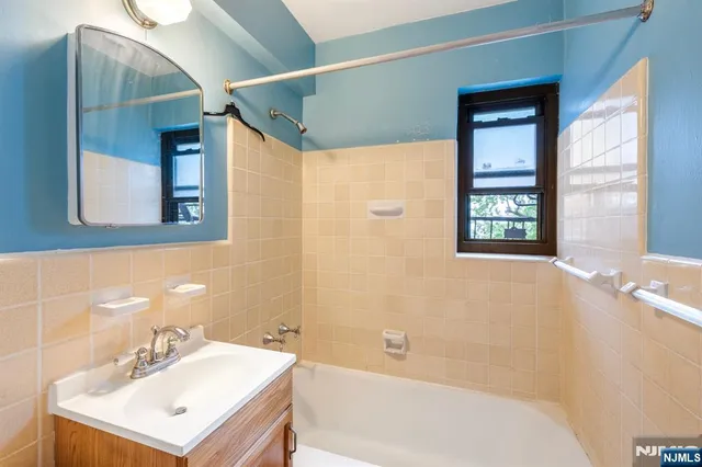 a bathroom with a sink mirror and a bathtub