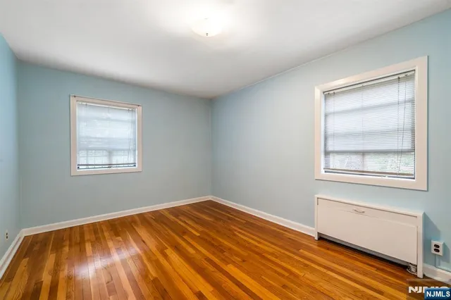 a view of a room with wooden floor and windows