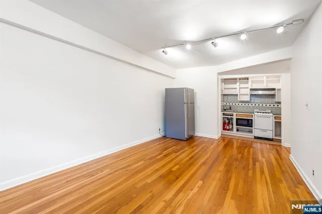 a view of empty room with wooden floor