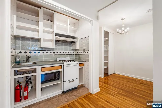 a view of a kitchen with stainless steel appliances granite countertop a stove and a refrigerator