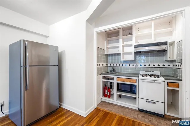 a kitchen with stainless steel appliances granite countertop a refrigerator and a stove