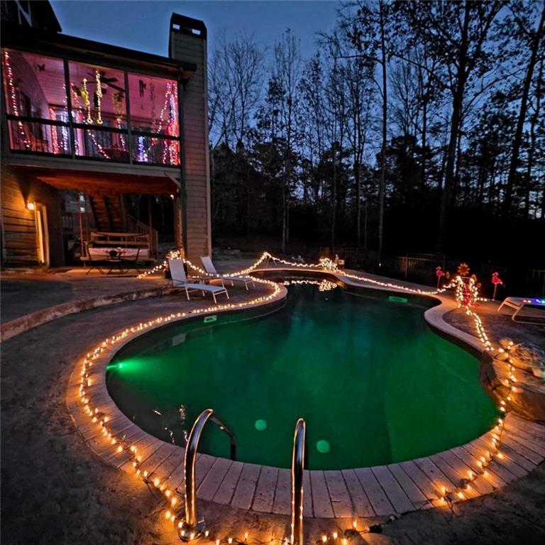 5175 Stefan Ridge Way Buford, GA 30519 - Photo 36 of 38 a view of a swimming pool with lawn chairs under an umbrella