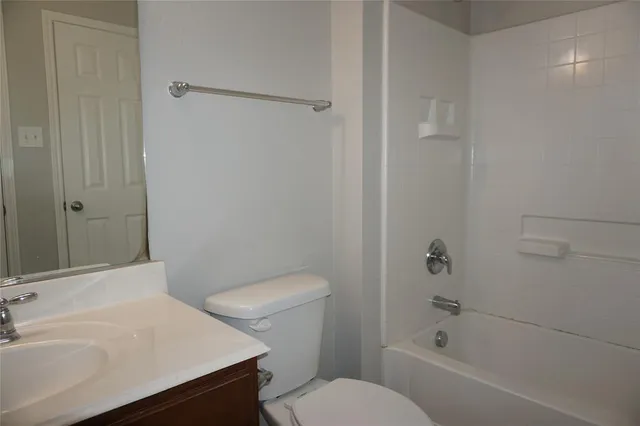 a white toilet sitting next to a bath tub