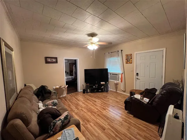a living room with furniture a flat screen tv and a mirror