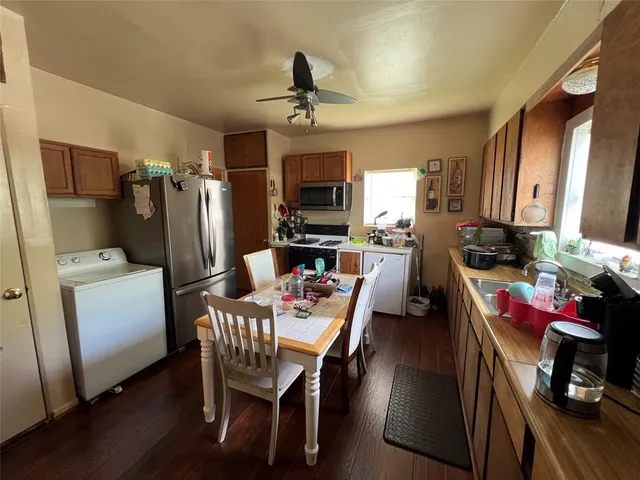 a kitchen with sink refrigerator dining table and chairs