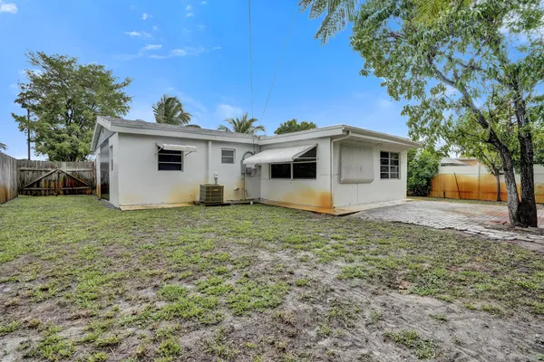 a view of a house with backyard and a tree