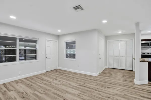 a view of a kitchen with wooden floor and a refrigerator
