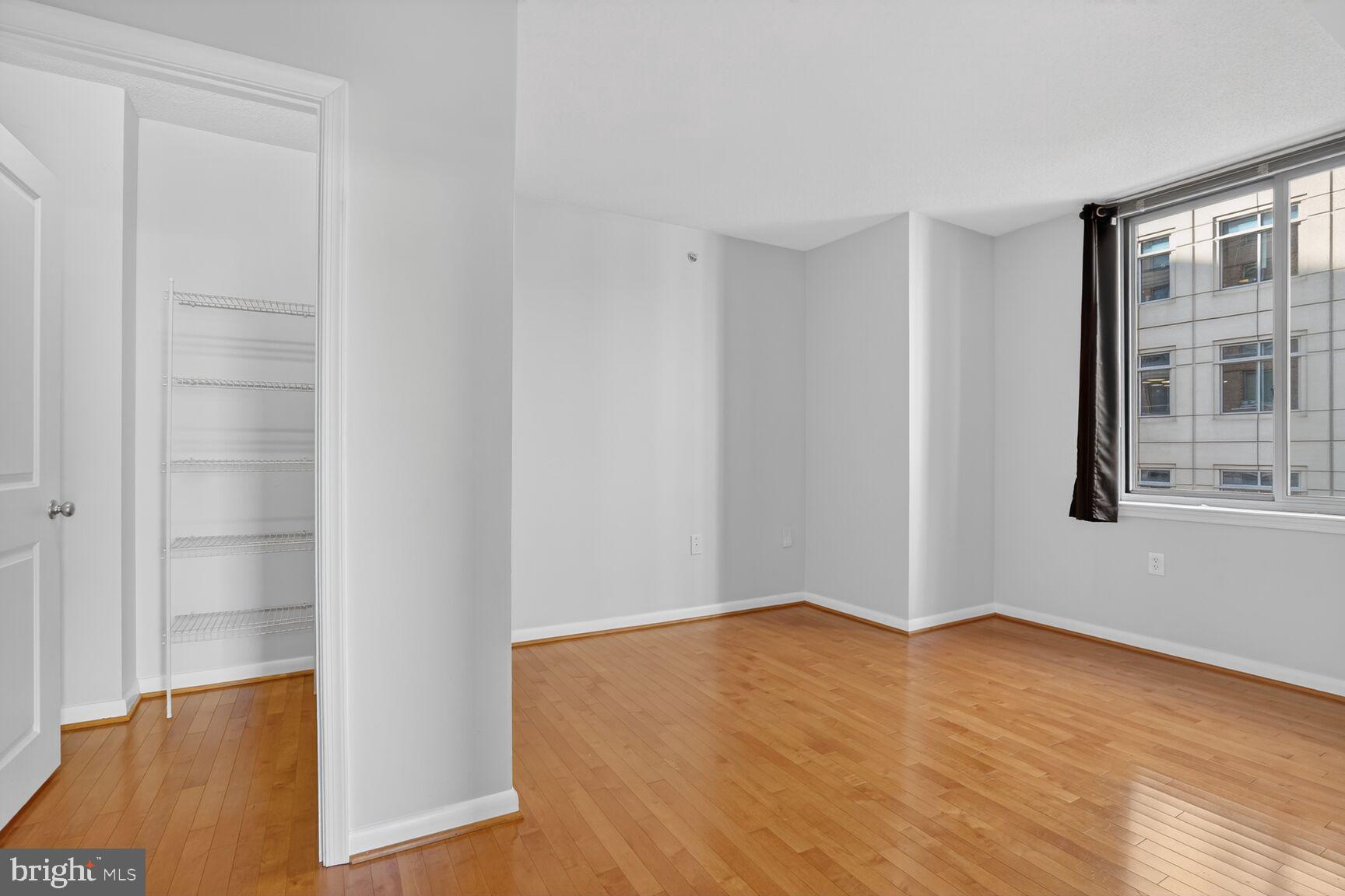 851 North Glebe Road, Unit 417 Arlington, VA 22203 - Photo 13 of 38 a view of an empty room with wooden floor and a window
