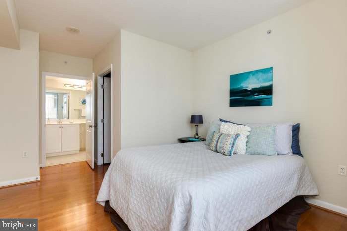 851 North Glebe Road, Unit 417 Arlington, VA 22203 - Photo 14 of 38 a bedroom with a bed and wooden floor