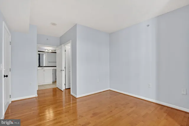 a view of empty room with wooden floor