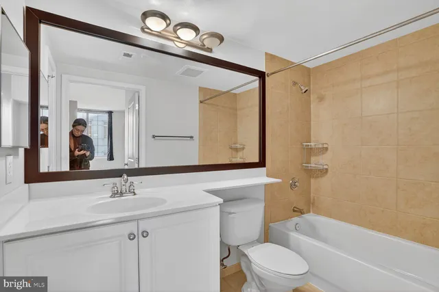 a bathroom with a sink a toilet a mirror and shower