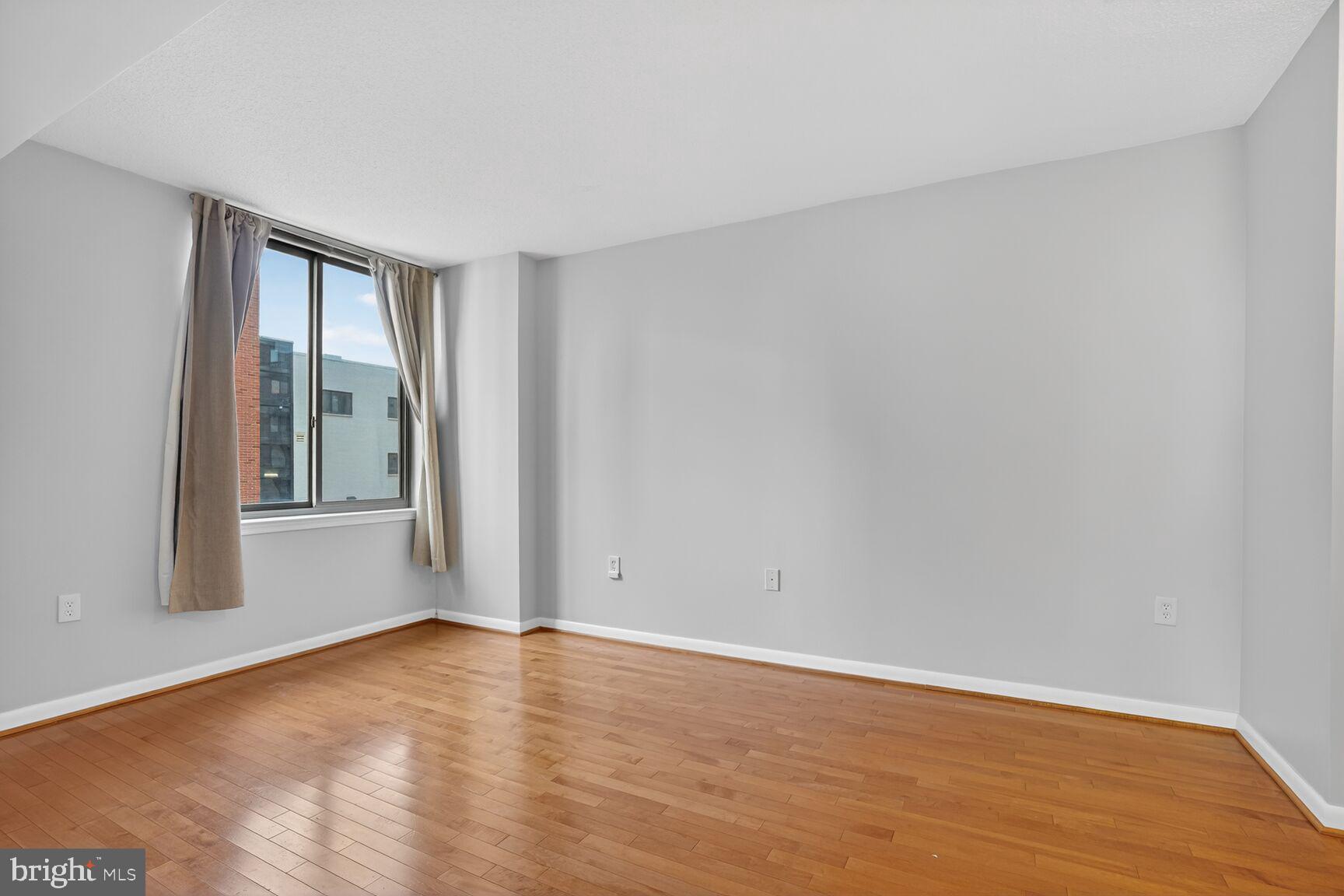 851 North Glebe Road, Unit 417 Arlington, VA 22203 - Photo 23 of 38 a view of an empty room with wooden floor and a window