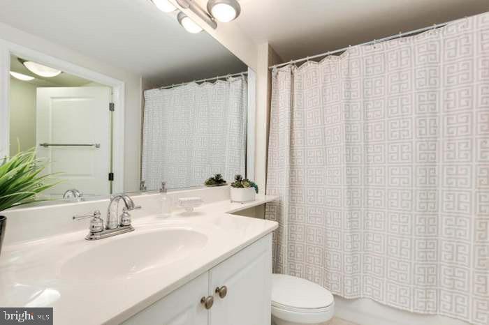 851 North Glebe Road, Unit 417 Arlington, VA 22203 - Photo 25 of 38 a bathroom with a sink a toilet and shower curtain
