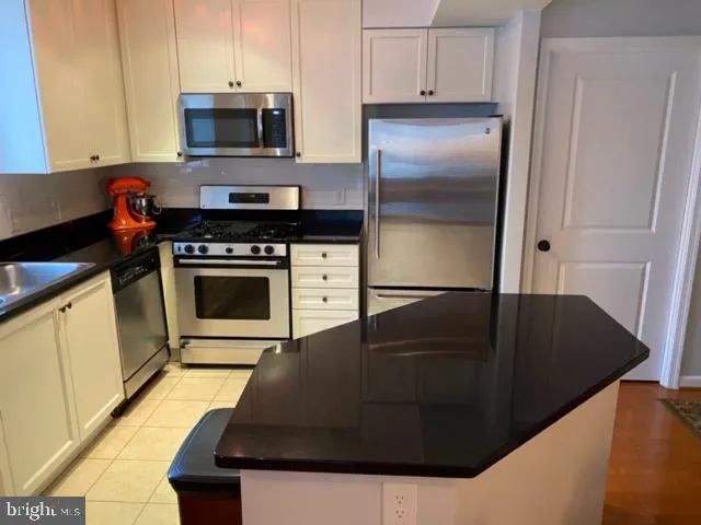 a kitchen with a refrigerator stove and cabinets
