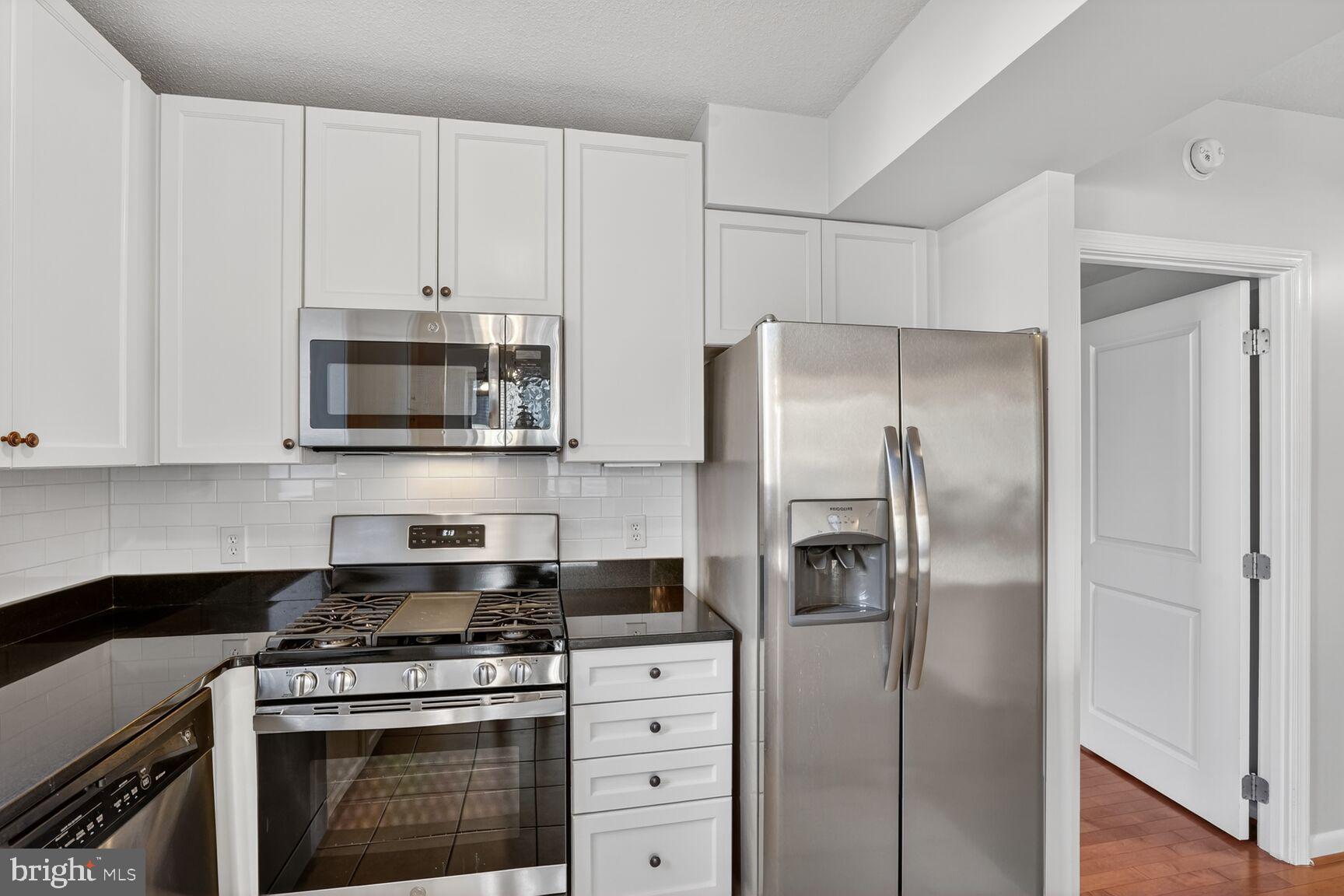 851 North Glebe Road, Unit 417 Arlington, VA 22203 - Photo 9 of 38 a kitchen with stainless steel appliances white cabinets and a stove