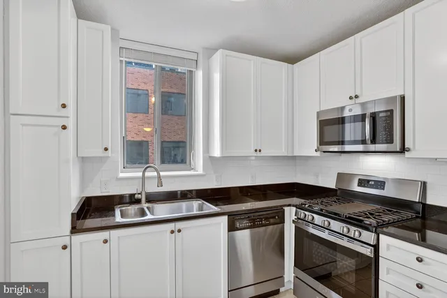 a kitchen with stainless steel appliances granite countertop a sink and a stove