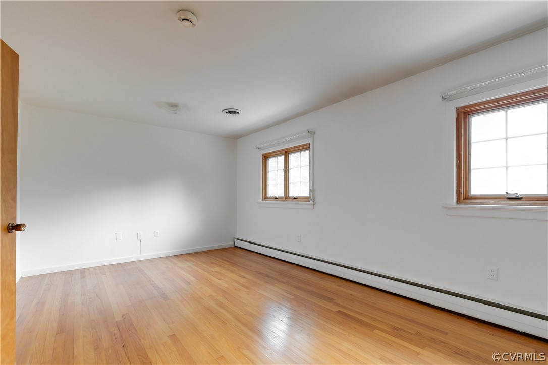 8946 Cherokee Road Richmond, VA 23235 - Photo 21 of 30 an empty room with wooden floor and windows