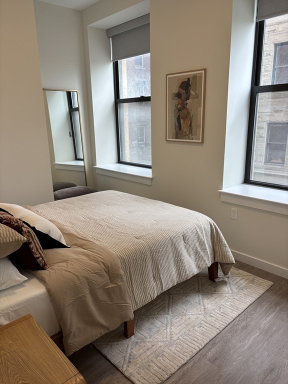 47 Winter Street, Unit 601 Boston, MA 02108 - Photo 5 of 12 a bedroom with a bed and a window