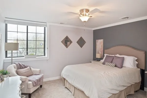 a bedroom with a large bed and a chandelier