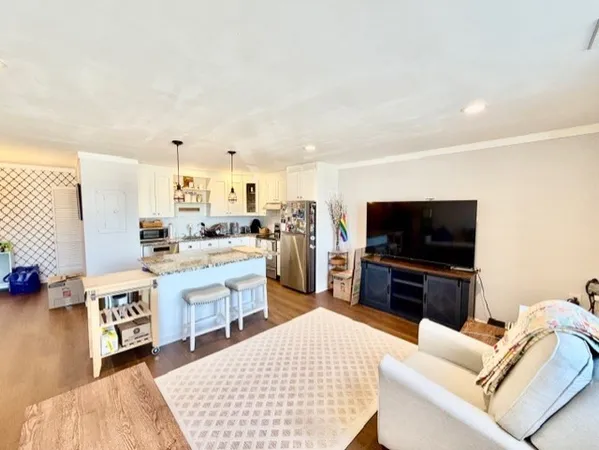 a open kitchen with stainless steel appliances kitchen island granite countertop a refrigerator and a sink