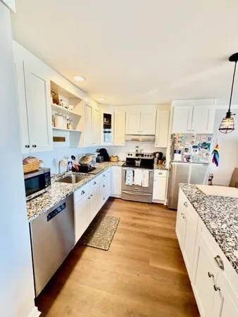 a large white kitchen with stainless steel appliances