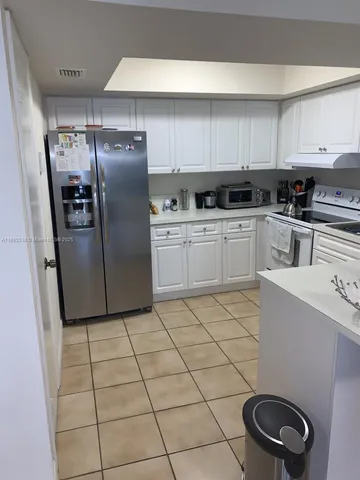 a kitchen with a refrigerator sink and cabinets