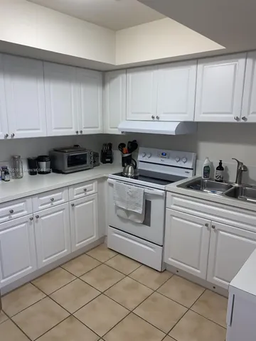 a kitchen with granite countertop white cabinets and white appliances