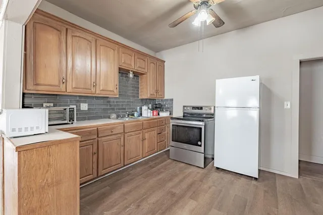 a kitchen with a refrigerator sink and cabinets