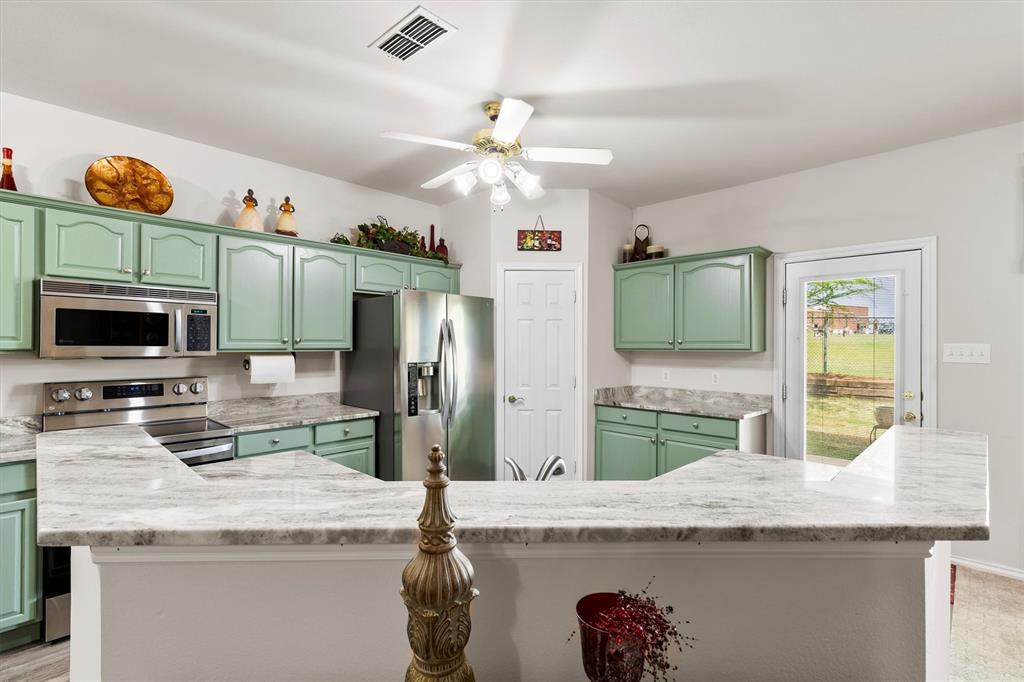 3505 Austin Street Gainesville, TX 76240 - Photo 2 of 20 a kitchen with granite countertop stainless steel appliances and a counter space