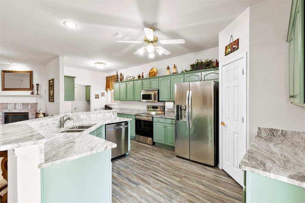 3505 Austin Street Gainesville, TX 76240 - Photo 3 of 20 a kitchen with stainless steel appliances granite countertop a refrigerator a stove and a sink
