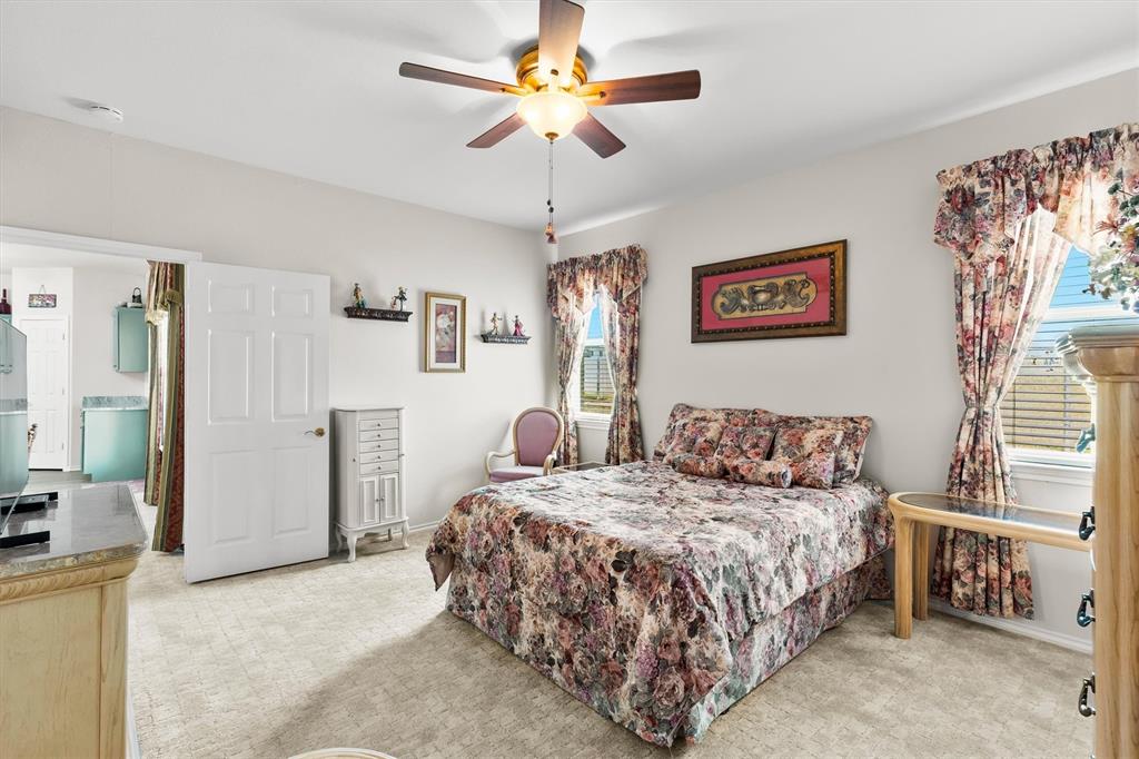 3505 Austin Street Gainesville, TX 76240 - Photo 9 of 20 a bedroom with a bed and a chandelier