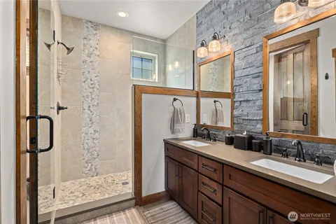 a bathroom with double vanity and a shower