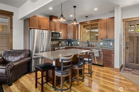 a kitchen with a table chairs refrigerator and microwave