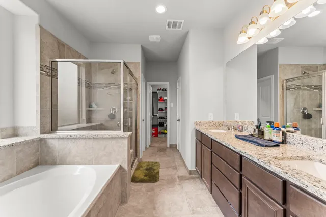 a bathroom with a tub sink and mirror