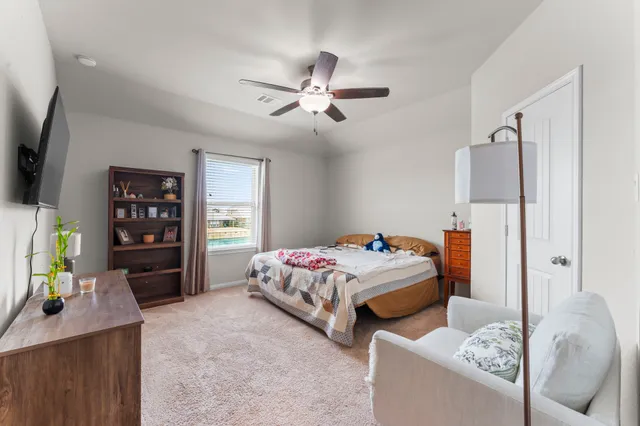 a bedroom with bed and a flat tv screen on dresser